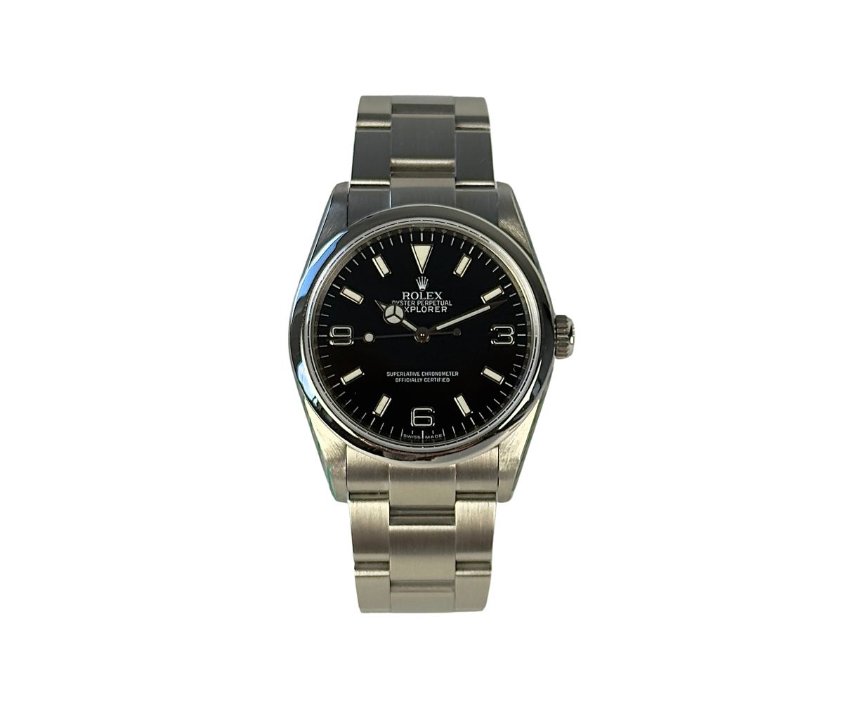 Rolex Explorer 114270 (2008) i stål med ROLEX i rehaut. Uret måler 36 mm, er vandtæt til 100 meter og i nær ny stand uden brugsspor, 9.5/10. Kommer som fuldt sæt: Bokse, certifikat, manualer, hangtag,whitetag og 2026 Rolex-service med servicestickers
