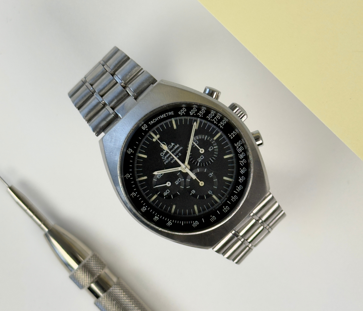 Omega Speedmaster Mark II 145.014 (1970'erne) i stål på lænke samt tilhørende natorem. Uret fremstår i alm. stand med brugsspor, 7.5/10. Kommer uden tilbehør.