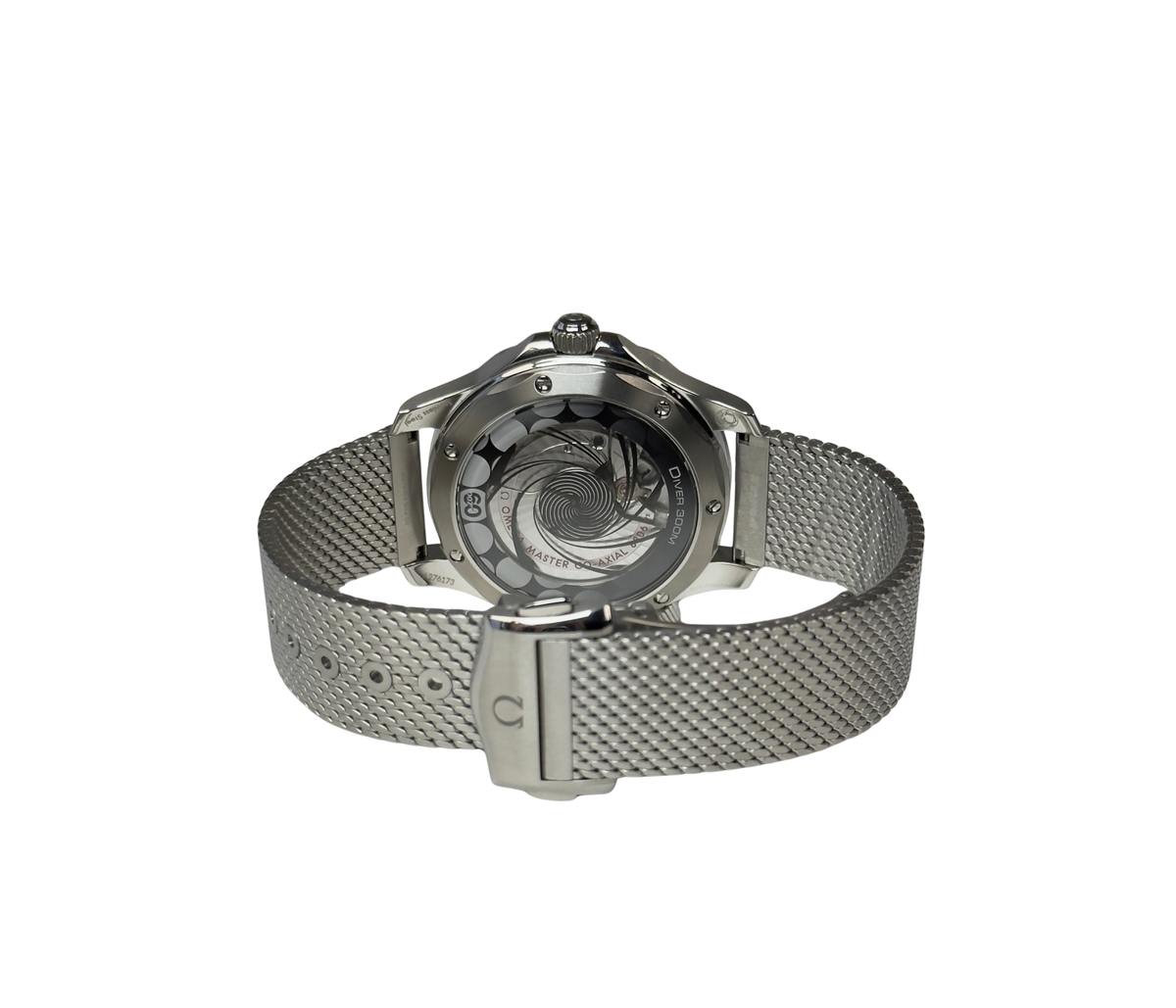 Omega Seamaster Diver 300M James Bond 60th Anniversary 210.30.42.20.03.002 (2026) i stål med blå oxideret aluminiumsurskive med lasergraverede bølger. Uret måler 42 mm og er udstyret med en flot mesh-lænke. Uret fremstår i mint stand uden brugsspor og er delvist i fabriksfolie, 10/10. 
Kommer som fuldt sæt: Bokse, certifikater, manual mv. 
Uret er solgt fra forhandler i Cannes i marts 2026.