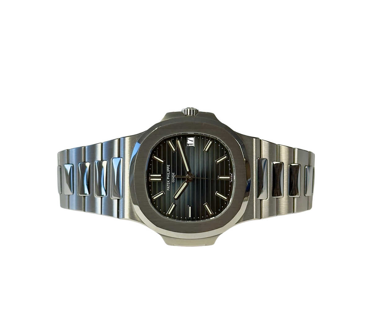 Patek Philippe Nautilus 5711/1A (2014) i stål med blå skive og integreret lænke. Uret måler 40 mm med en tykkelse på 8.6 mm, hvilket giver uret en elegant lav profil på håndleddet.
Uret fremstår i utroligt flot og upoleret stand med mindre brugsspor, +9/10.
Kommer som fuldt sæt: Bokse, certifikat, manualer, lædermappe mv. 