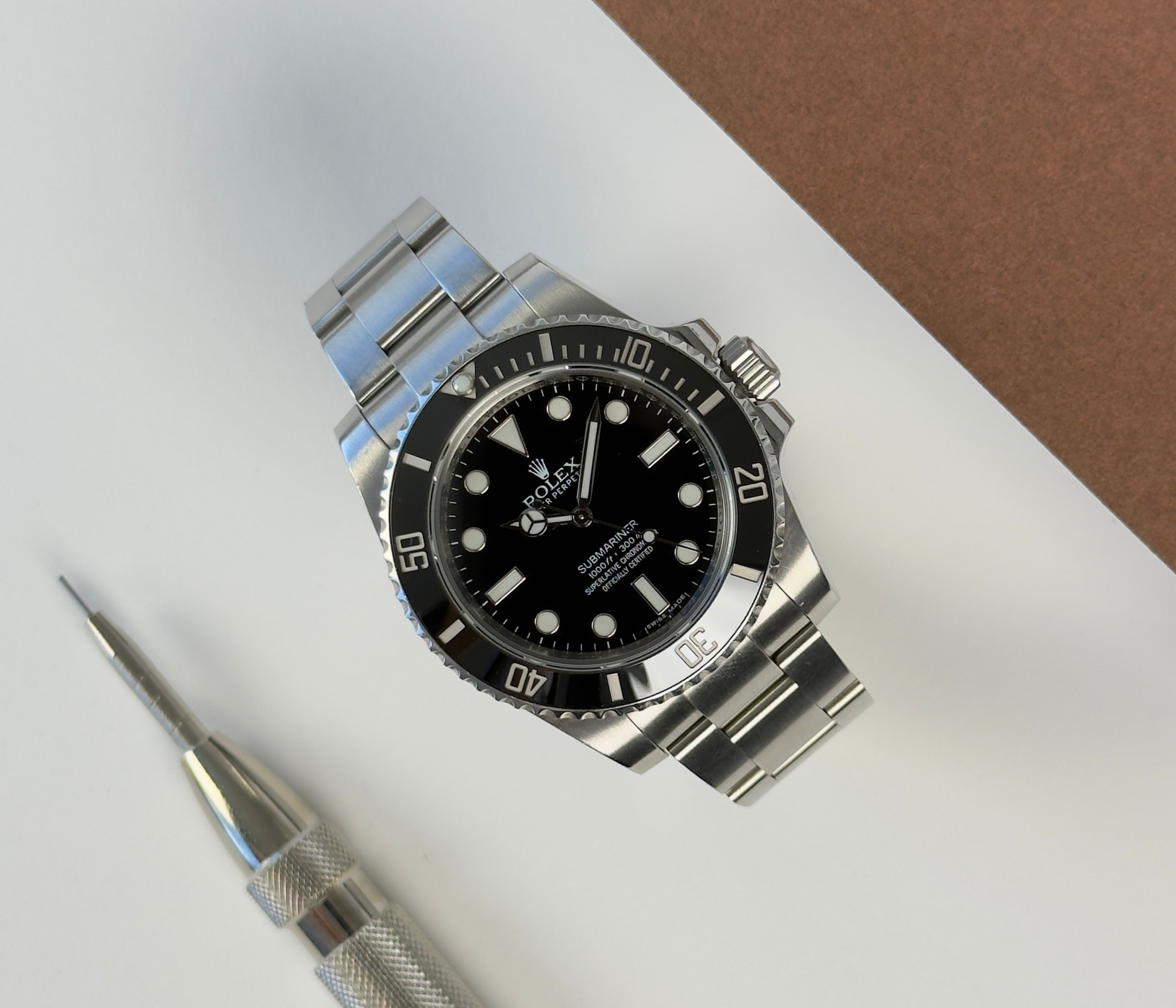 Rolex Submariner 114060 "No Date" (2013) på Oysterlænke med sort skive og drejekrans. Uret fremstår i god alm. stand, 8/10. Det kommer med boks, certifikat og green tag. 