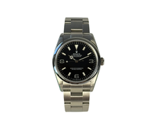 Rolex Explorer 114270 (2008) i stål med ROLEX i rehaut. Uret måler 36 mm, er vandtæt til 100 meter og i nær ny stand uden brugsspor, 9.5/10. Kommer som fuldt sæt: Bokse, certifikat, manualer, hangtag,whitetag og 2026 Rolex-service med servicestickers