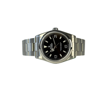 Rolex Explorer 114270 (2008) i stål med ROLEX i rehaut. Uret måler 36 mm, er vandtæt til 100 meter og i nær ny stand uden brugsspor, 9.5/10. Kommer som fuldt sæt: Bokse, certifikat, manualer, hangtag,whitetag og 2026 Rolex-service med servicestickers