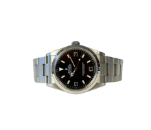Rolex Explorer I 114270 (2002) i stål på Oysterlænke med sort Explorer-skive. Uret fremstår i rigtig flot stand, 8.5/10. Kommer med originalt certifikat, grønt hangtag samt et ekstra led. 
Y-serie (Y86XXXX) fra 01/02 solgt i 2003. 