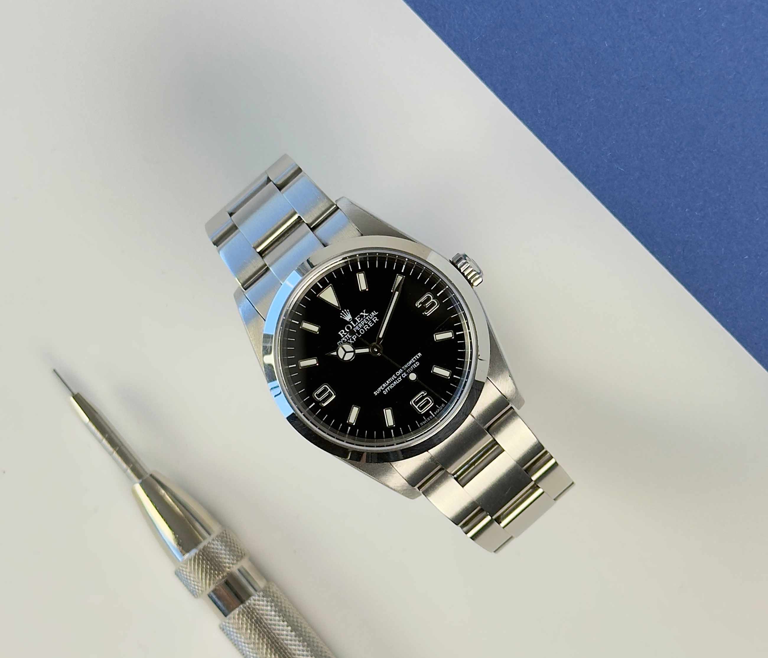 Rolex Explorer I 114270 (2002) i stål på Oysterlænke med sort Explorer-skive. Uret fremstår i rigtig flot stand, 8.5/10. Kommer med originalt certifikat, grønt hangtag samt et ekstra led. 
Y-serie (Y86XXXX) fra 01/02 solgt i 2003. 