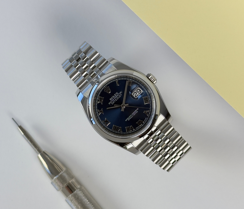 Rolex Datejust 116200 (2018) på jubilee-lænke og smooth krans med blå skive med romertal. Uret fremstår i rigtig flot stand, 9/19. Kommer som fuldt sæt:  boks, certifikat, manualer, kortholder og hangtag.