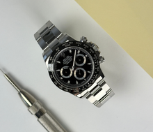 Rolex Daytona 116500LN (2018) med sort skive. Uret fremstår i utrolig flot stand, 9.5/10, med få brugsspor. Kommer som fuldt sæt: bokse, certifikat, manualer, hangtag og whitetag. 