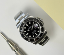 Rolex Submariner 116610LN (2010) i stål på Oysterlænke med sort skive- og drejekrans. Uret fremstår i alm. stand med brugsspor, dog ingen dybe ridser, 8/10. Kommer som fuldt sæt: Bokse, omslag, certifikat, manualer, kortholder og original købskvittering fra dansk AD.
