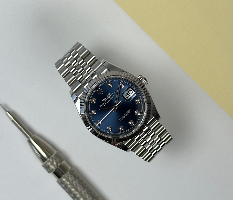 Rolex Datejust 126234 (2021) med en flot blå sunburst skive med diamanter. Kommer med hvidguldslynette og Jubileelænke.
Kommer som fuldt: Bokse, certifikat, manualer, hangtag, whitetag og tre ekstra led.