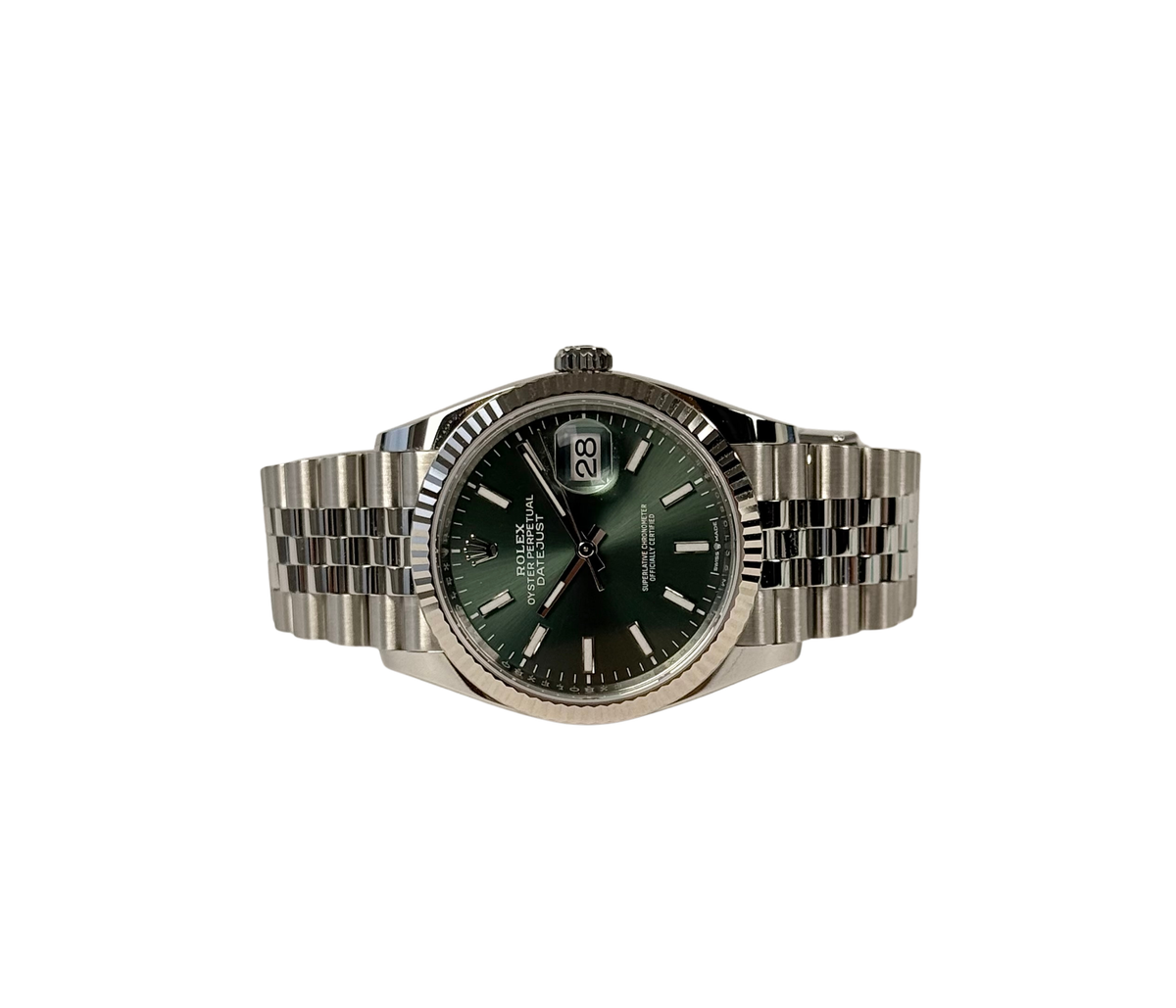 Rolex Datejust 126234 Mint green (2025) i stål på Jubilee-lænke med riflet krans i 18kt. hvidguld og grøn skive. Uret fremstår i nær ny stand med få håndteringsspor, 9.9/10. Kommer som fuldt sæt: Bokse (den nye), certifikat, manualer, kortholder, hangtag, whitetag og købskvittering fra dansk AD.