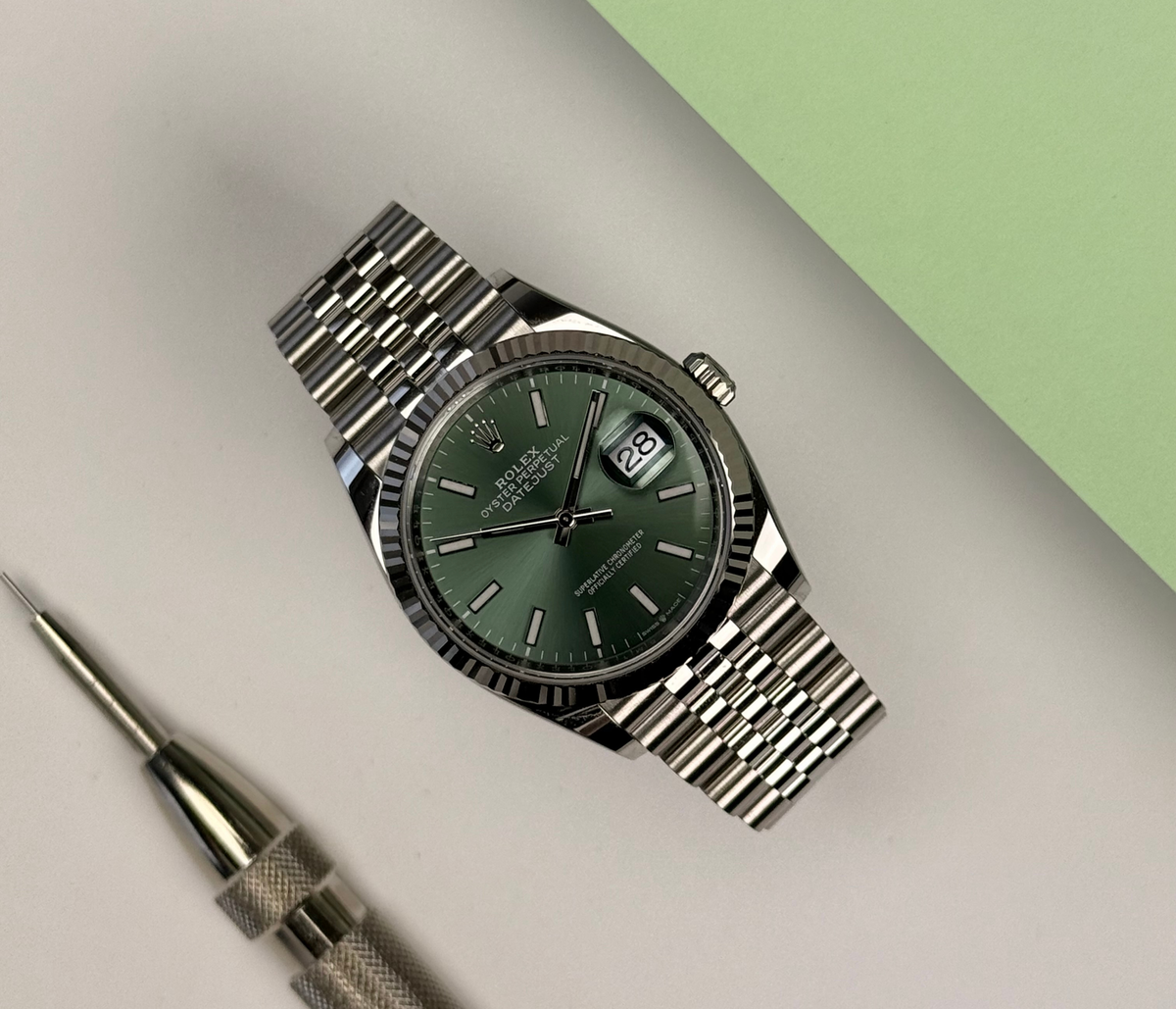 Rolex Datejust 126234 Mint green (2025) i stål på Jubilee-lænke med riflet krans i 18kt. hvidguld og grøn skive. Uret fremstår i nær ny stand med få håndteringsspor, 9.9/10. Kommer som fuldt sæt: Bokse (den nye), certifikat, manualer, kortholder, hangtag, whitetag og købskvittering fra dansk AD.