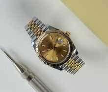 Rolex Datejust 126333 (2018) i 18kt. guld og stål. Uret måler 41 mm og er monteret på en two-tone Jubilee-lænke med riftet/fluted krans i guld og champagneskive. Uret fremstår i alm. stand med brugsspor som let kan poleres, 8/10. Kommer med boks, certifikat, manual og kortholder. 