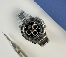 Rolex Daytona 126500LN (2024) i stål med sort skive. Uret fremstår i nær ny stand med få håndteringsspor, 9.5/10. Kommer som fuldt sæt: Bokse, certifikat, manualer, kortholder, købskvittering fra dansk AD og hangtag. 
Uret er omfattet af Rolex World Wide Garanti til 2029.