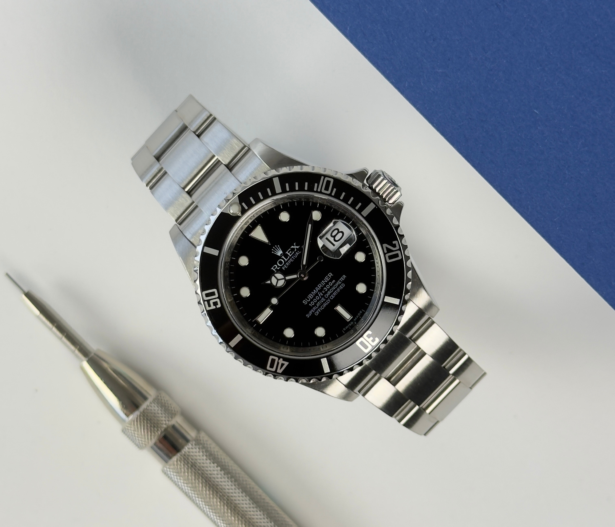 Rolex Submariner 16610 T V-serie (2009) solgt i 2010. Uret fremstår i flot stand, 9/10. Det måler 40 mm og er monteret på en Oysterlænke med sort aluminiumslynette. Kommer med bokse og certifikat.