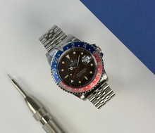 Rolex GMT-Master II 16710 "Pepsi" (1999) i stål på Jubilee-lænke. Uret fremstår i virkelig flot stand med utrolig flot patina af skive og indlæg, 9/10. Jubilee-lænken er nyrestaureret/opstrammet med nye stifter. Kommer med certifikat, manual og servicebevis fra AD.
Serienummer: A50XXXX