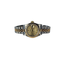 Rolex Datejust 79173 (2002) i guld og stål. Dette klassiske dame Datejust i 26 mm har en champagne Tapestry skive, jubileelænke og safirglas. Lænke uden stræk. Uret fremstår i rigtig flot stand, 9/10. Et utrolig flot og feminint ur, der er den perfekte kombination af ur og smykke. 