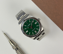 Rolex Oyster Perpetual 124300 (2023) i stål på Oysterlænke med grøn skive. Uret fremstår i rigtig flot stand med mindre bruggspor, 9.5/10. Kommer som fuldt sæt: Bokse, certifikat, manualer, kortholder og hangtag.
Uret er omfattet af Rolex World Wide Garanti til juni 2028.