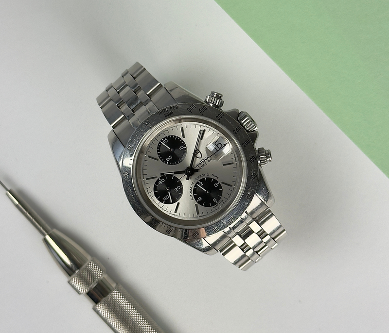 Tudor Oysterdate Chronograph 79180 (2007) i stål på Jubileelænke. Uret fremstår med brugsspor og kan let poleres for nyt udtryk. Det kommer med bokse, certifikat, maunal og holder. 