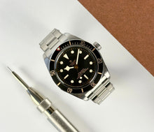 Tudor Black Bay 58 (Okt. 2025) i stål. Uret måler 39 mm og kommer på en stållænke samt original natorem. Fremstår i mint stand uden brugsspor. Kommer som fuldt sæt: Bokse, certifikat mv.