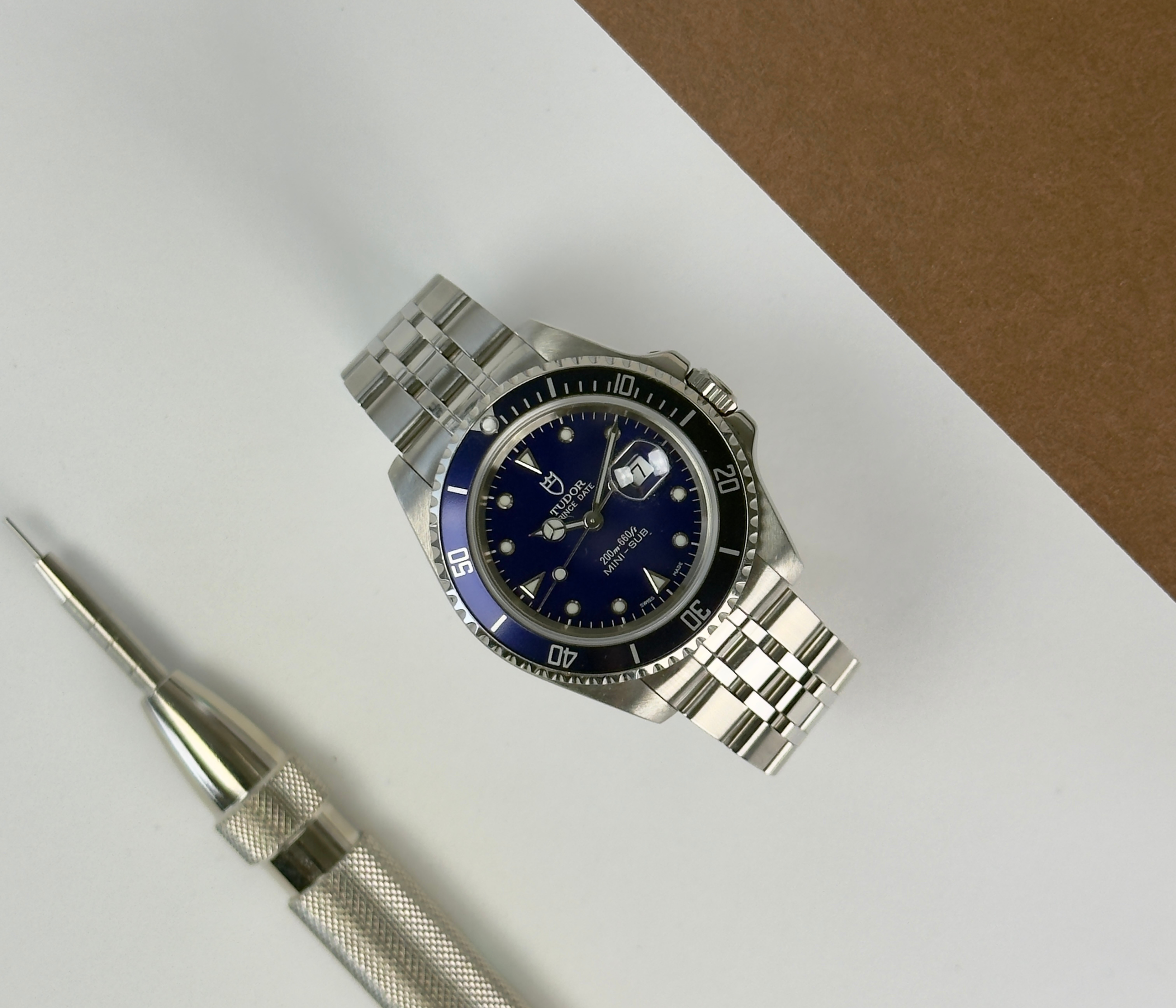 Tudor Mini Sub 73190 (1990'erne) på Jubileelænke med blå skive- og krans. Uret måler 33 mm og bæres større pga. designet. Det fremstår i rigtig flot stand. Kommer uden tilbehør.